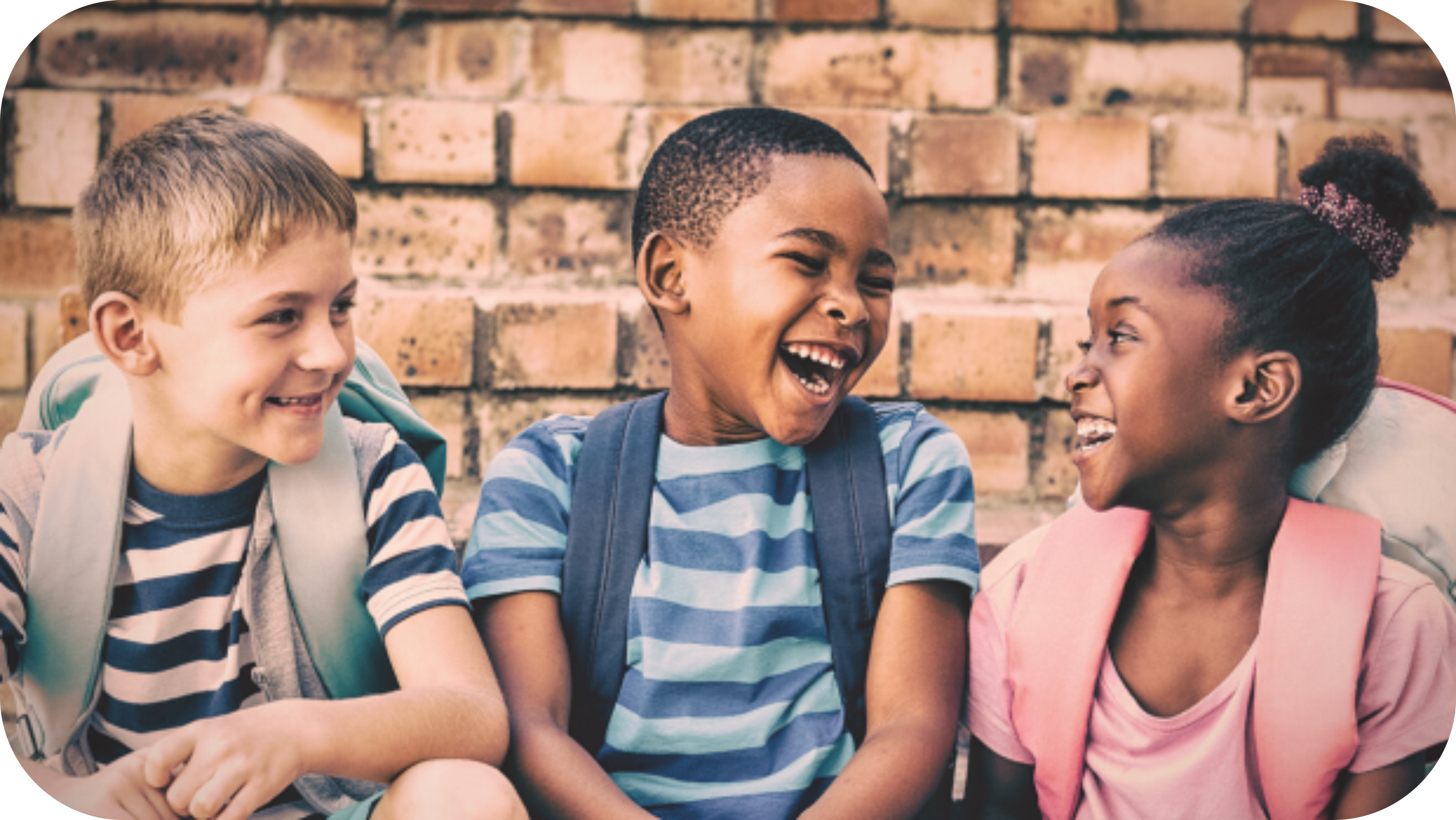 Três crianças sorrindo na escola